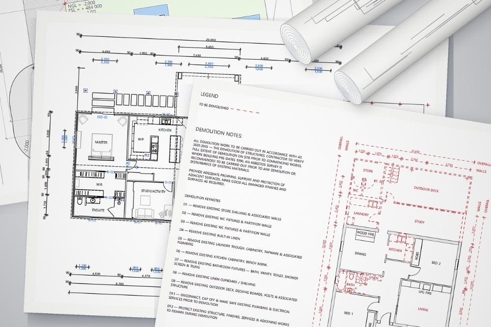 Architectural blueprints of a residential house on a wooden desk with a pencil-